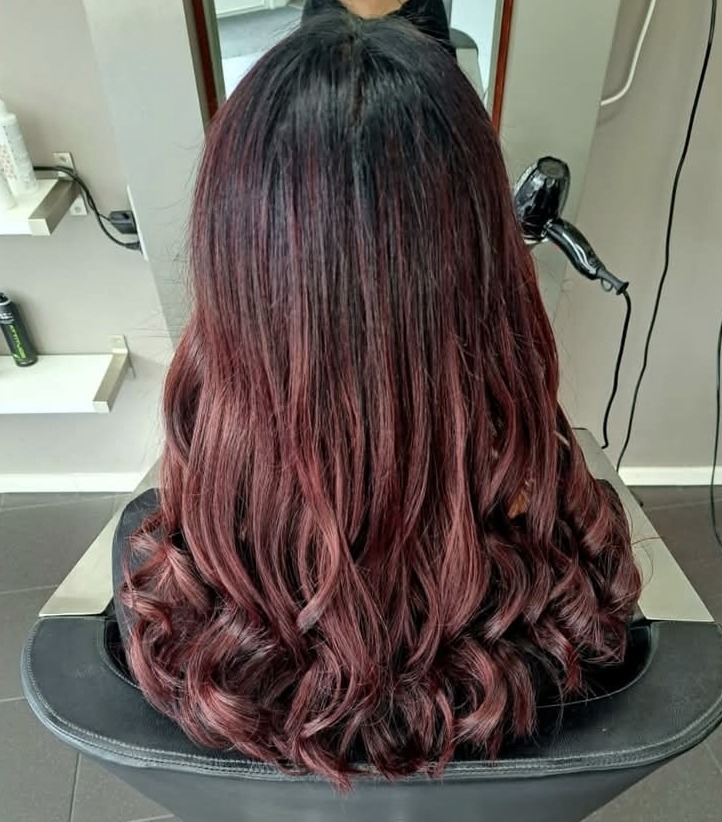 Lang haar met een rode ombré en krullen, van achteren gezien