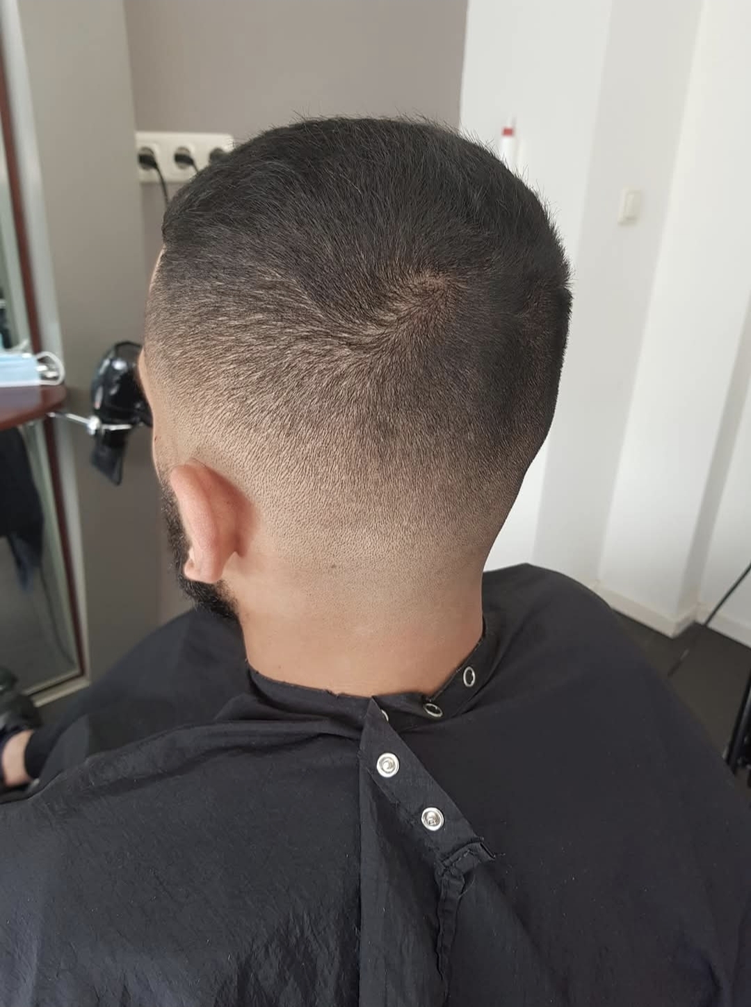 Korte herensnit met strakke fade, van achteren gezien